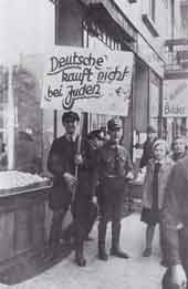 Homme tenant un panneau appelant au boycott des magasins appartenant  des Juifs