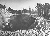 Membres des Einsatzgruppen faisant feu sur un groupe d'hommes debout dans une fosse. Circa 1941-1942