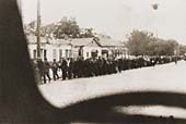 Jewish  columns guarded by German soldiers being led through the streets of Kamenetz-Podolsk, Ukraine, towards an execution site on the outskirts of the town